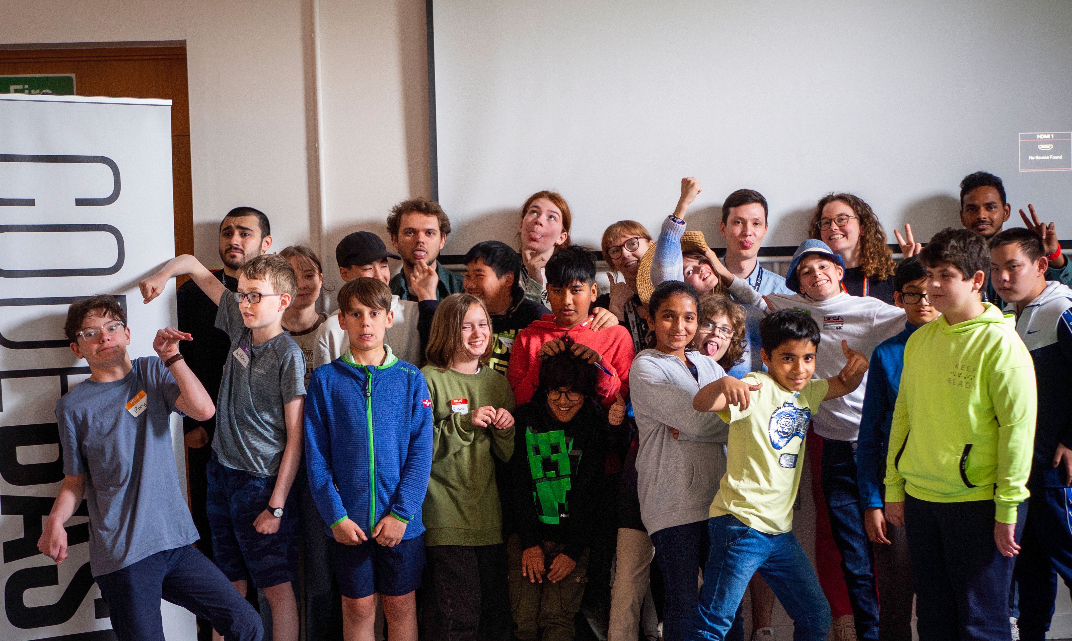 A large group of mentors and attendees making silly faces at the camera