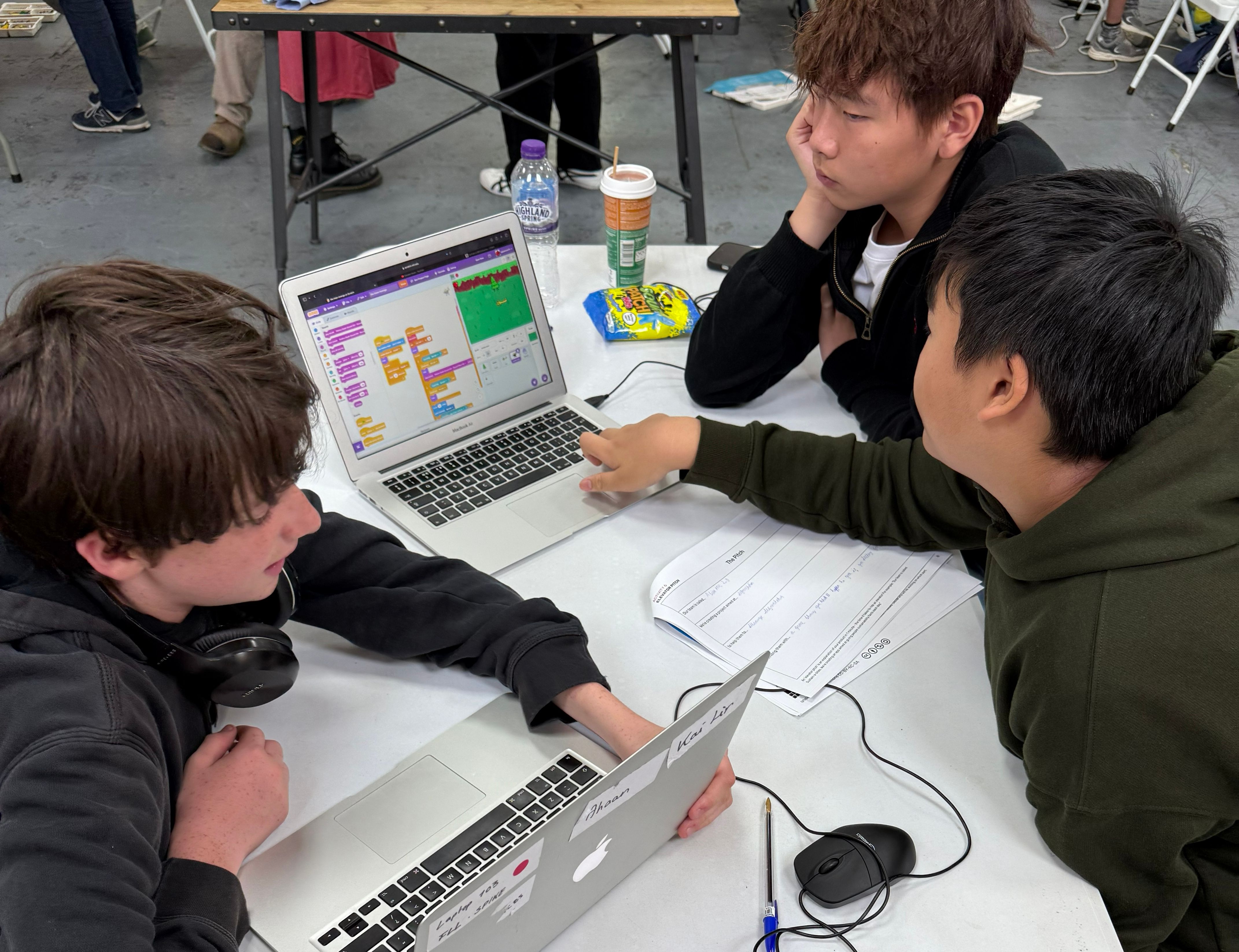 Three attendees working together on a Scratch project
